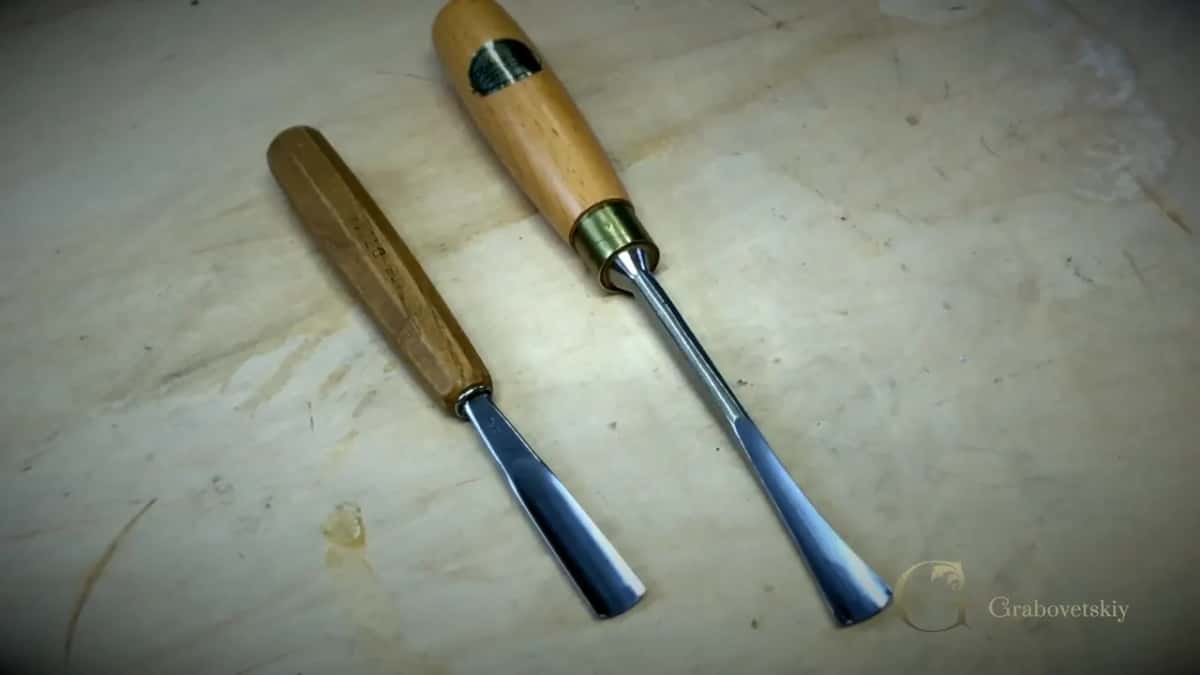 Two gouges side by side on the board, handles different, blades close in width.