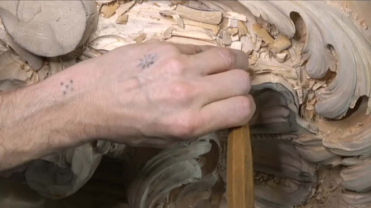 Held almost upright, a gouge works the rim beside a deep hollow in the shell.