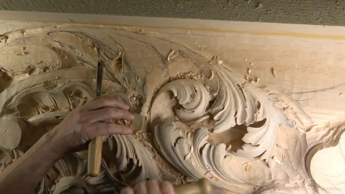 An upright gouge beside rows of carved leaves.