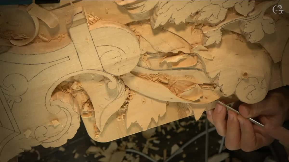 One hand reaches under the lower right leaves with a slender tool.