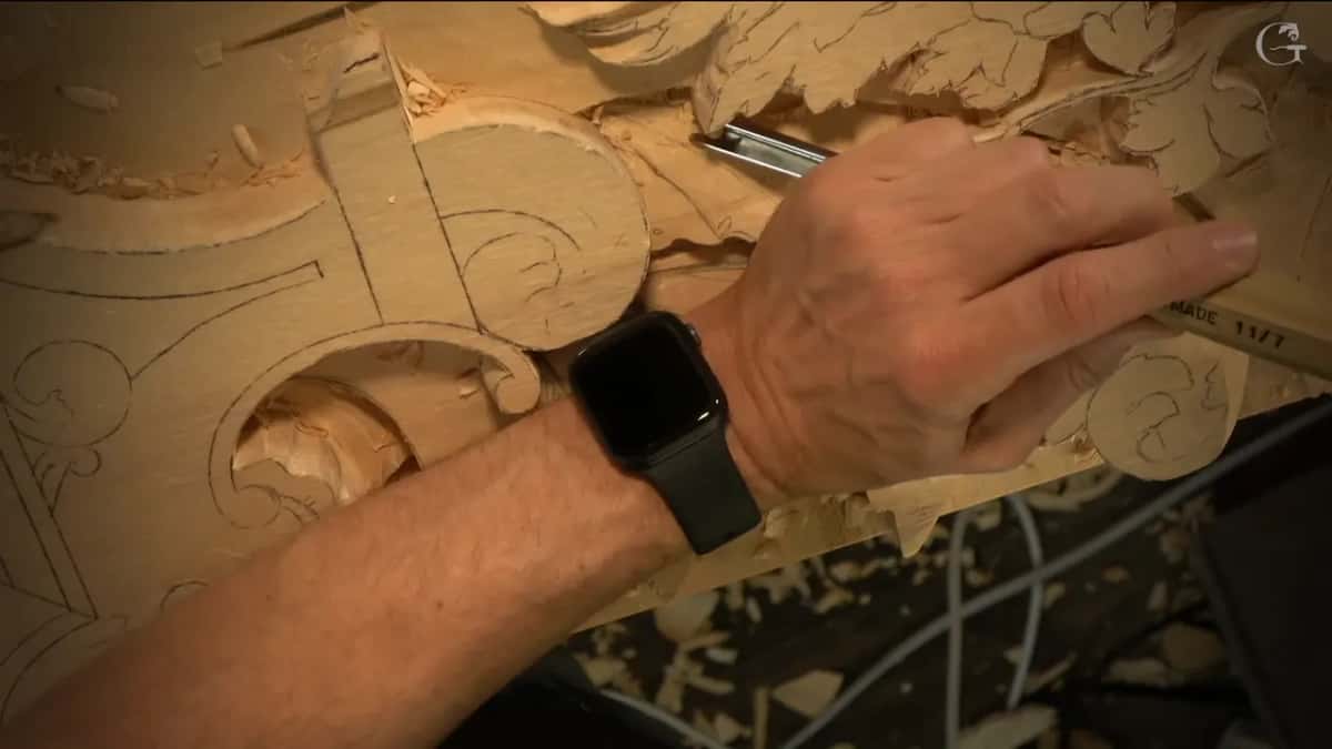 His right hand guides a gouge past a scroll.
