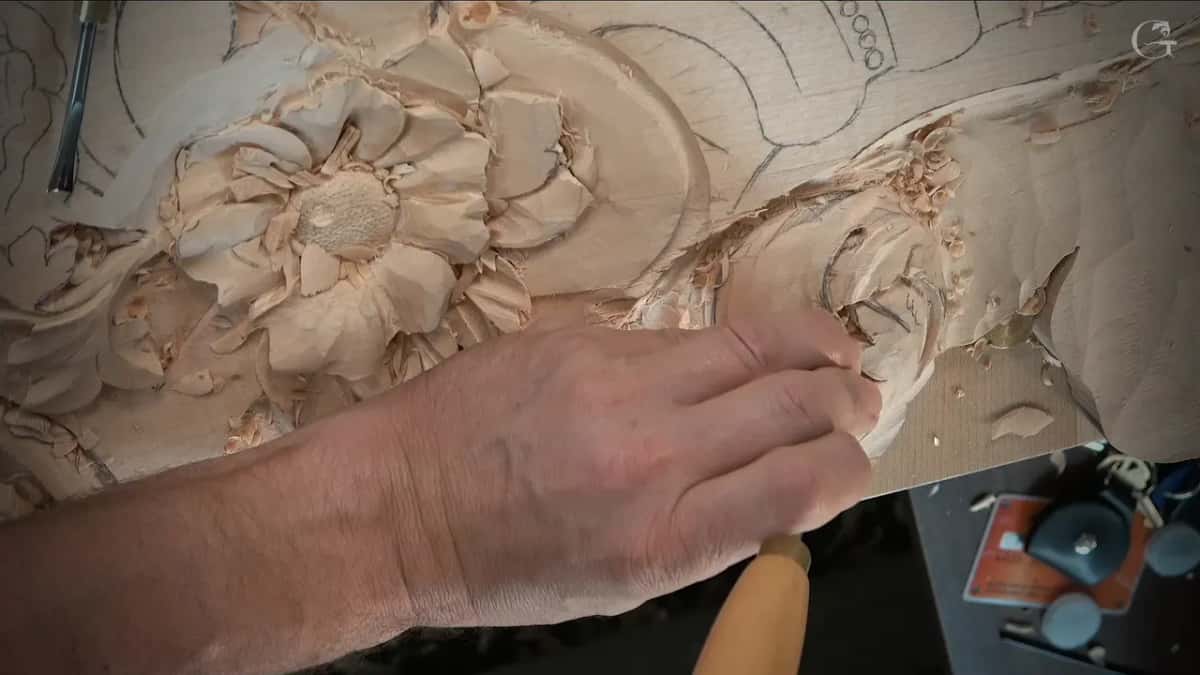 A fist over the scroll, handle low in the frame
