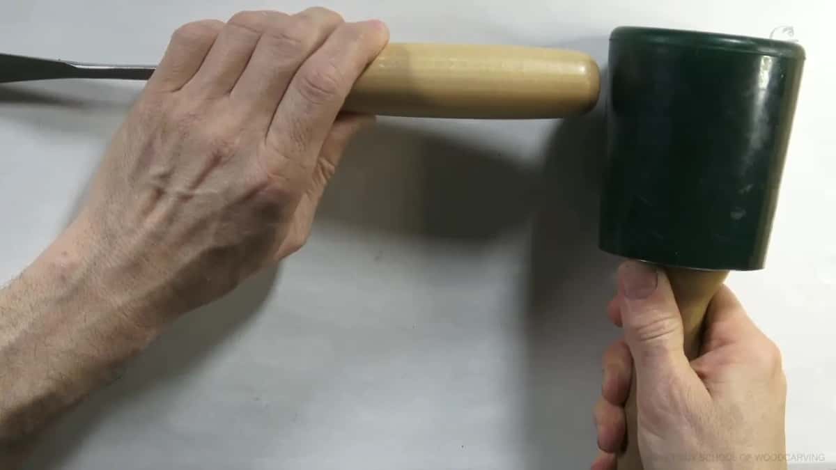 Gripped by its handle, the mallet fills the frame with the gouge just at the edge.
