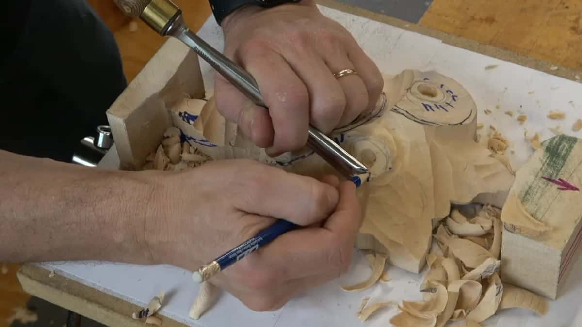 Gouge in one hand, pen still in the other