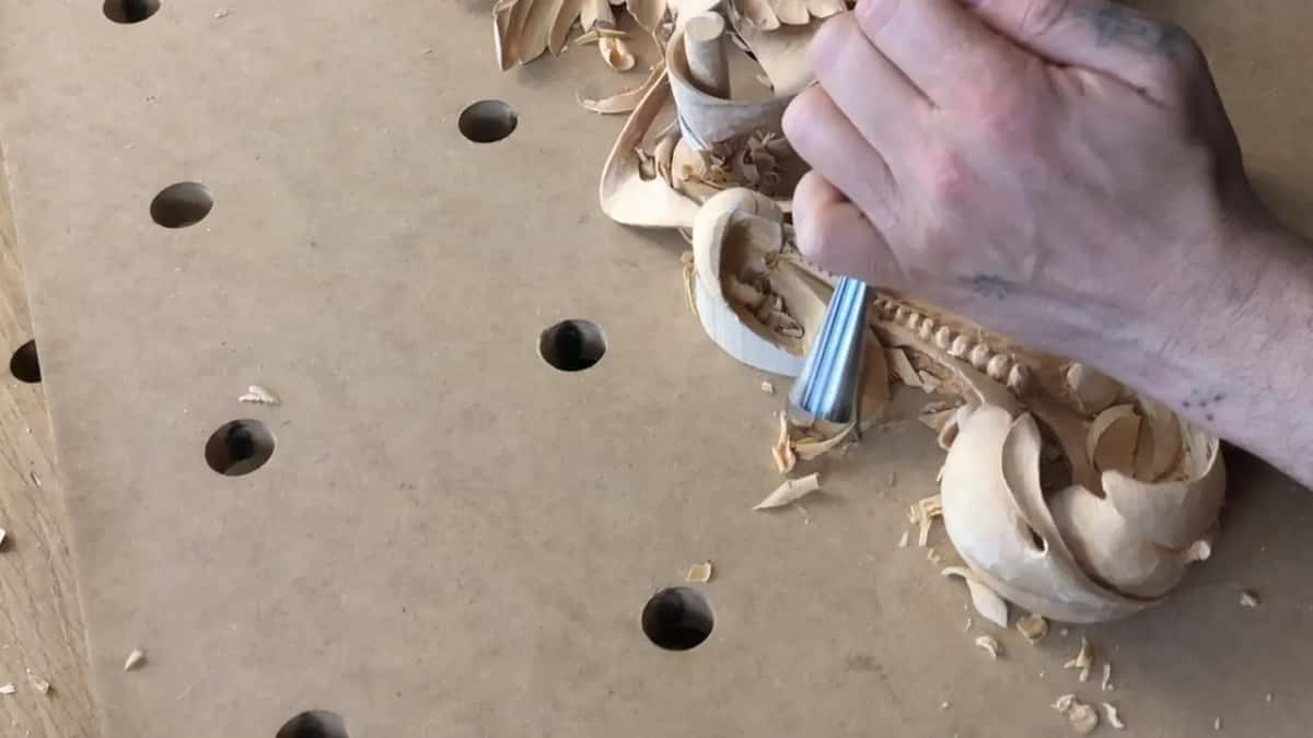 Mostly bare board in this frame, and one fist driving a gouge into a curl at the top