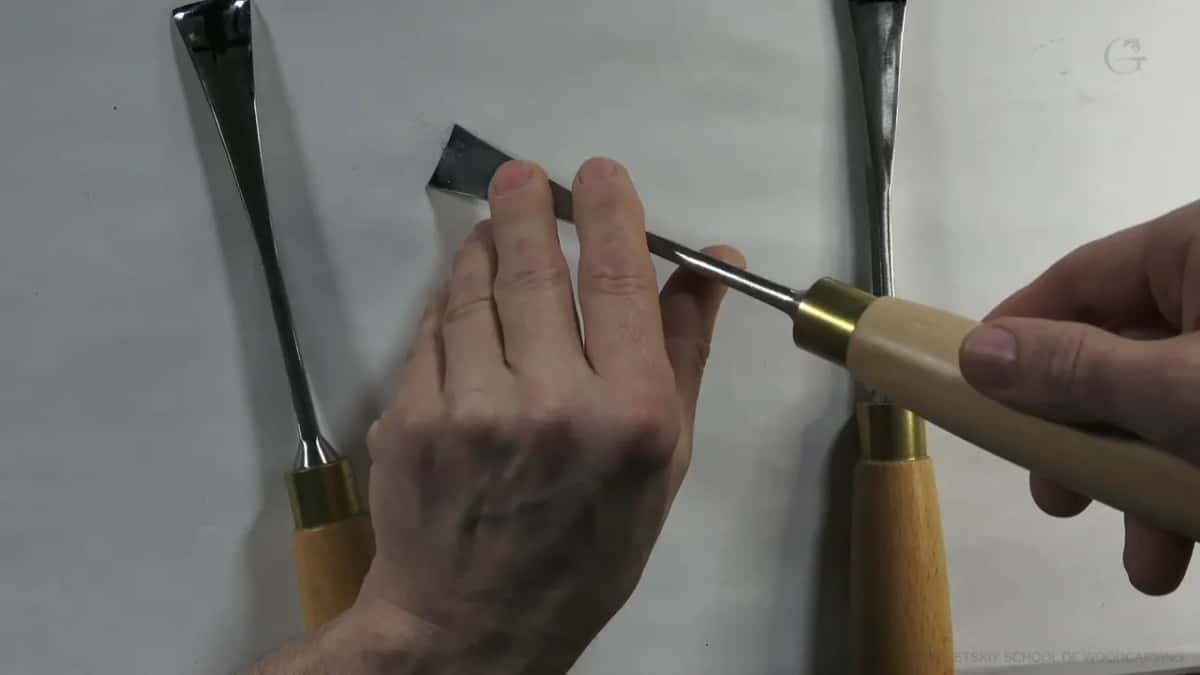 Small gouge with its bevel set on the fingers of the guiding hand, which is how you check the handle sits low.