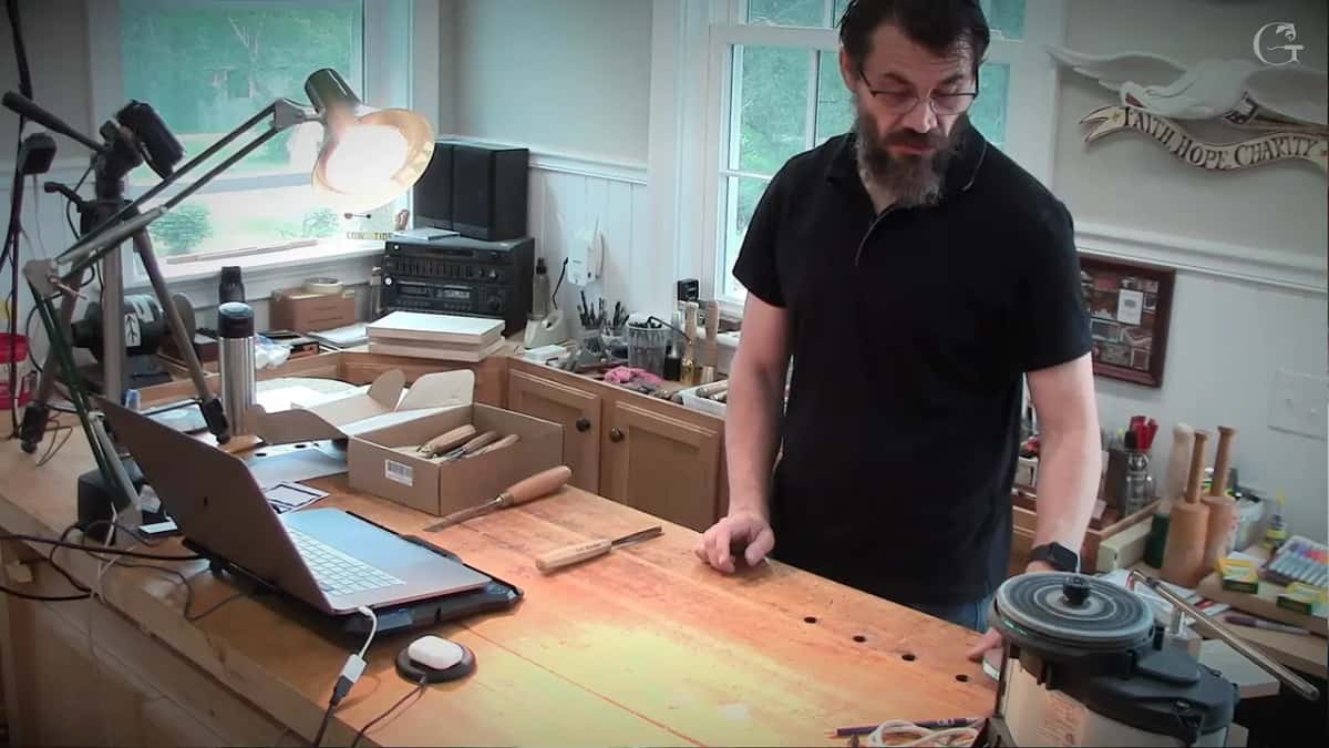 One hand open above the bench, showing where a tool should sit.