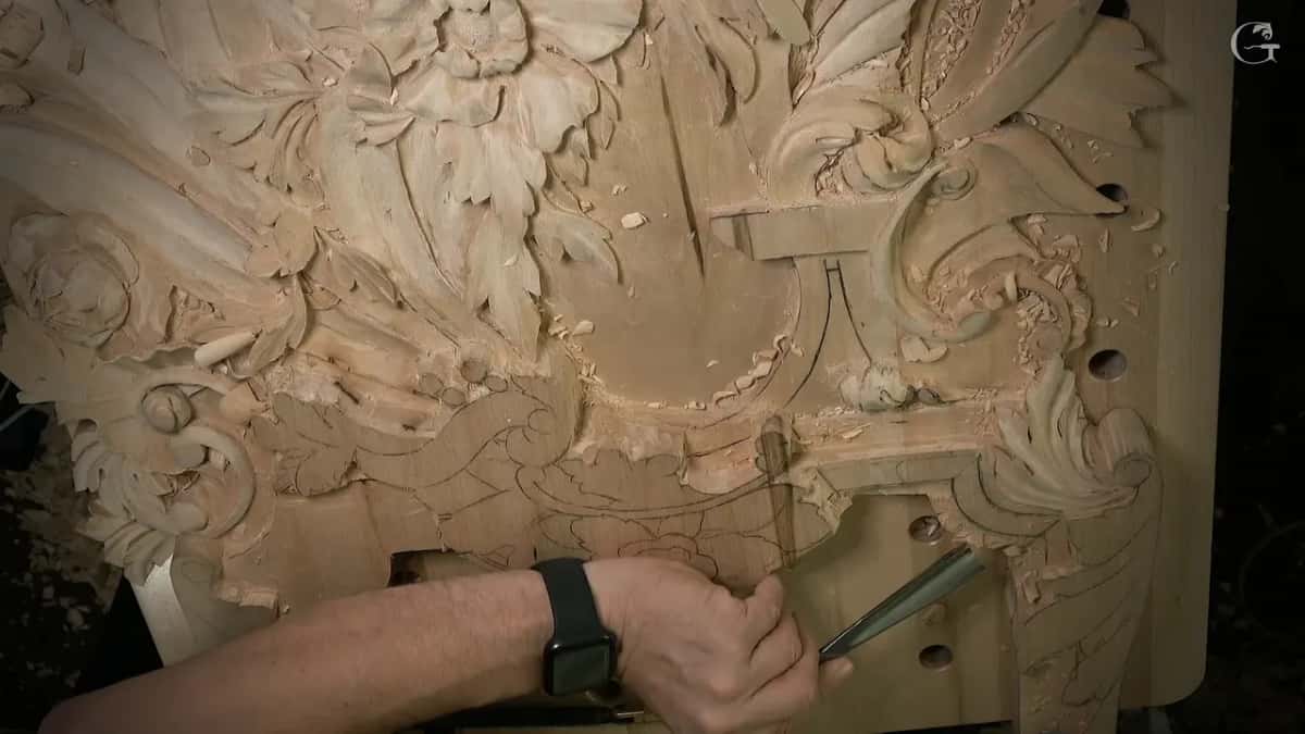 Gouge held below the carved leaves, a pencil flower under it
