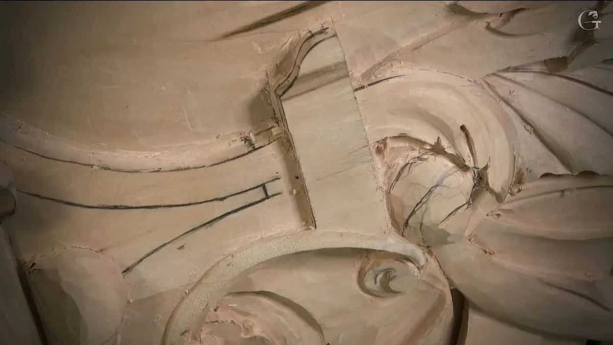 Dark pencil lines run past a narrow slot beside a carved curl