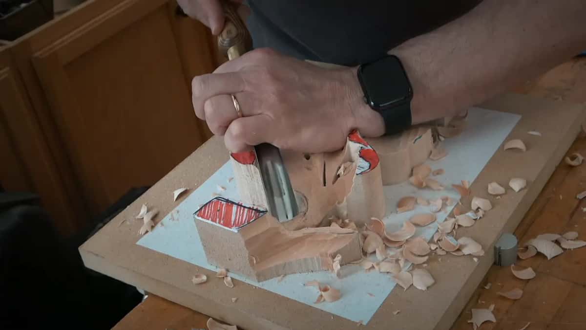 Both hands steering a gouge down the side