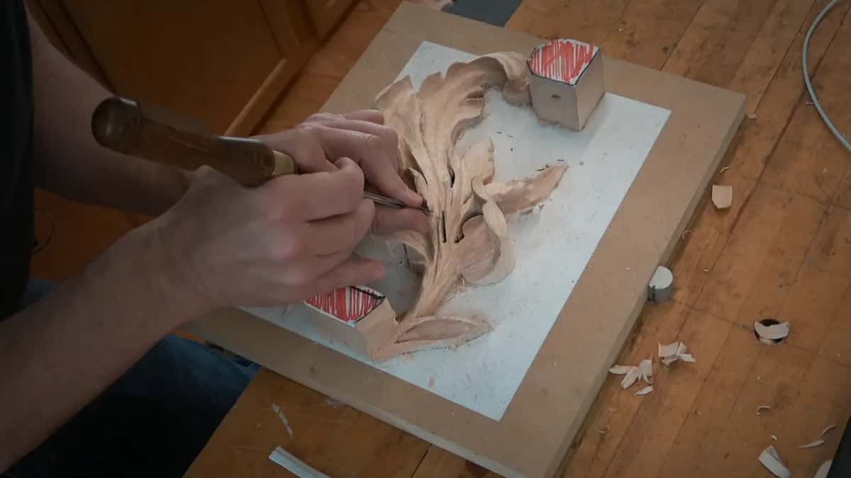 One hand on the handle, the other near the blade, close to the lower block