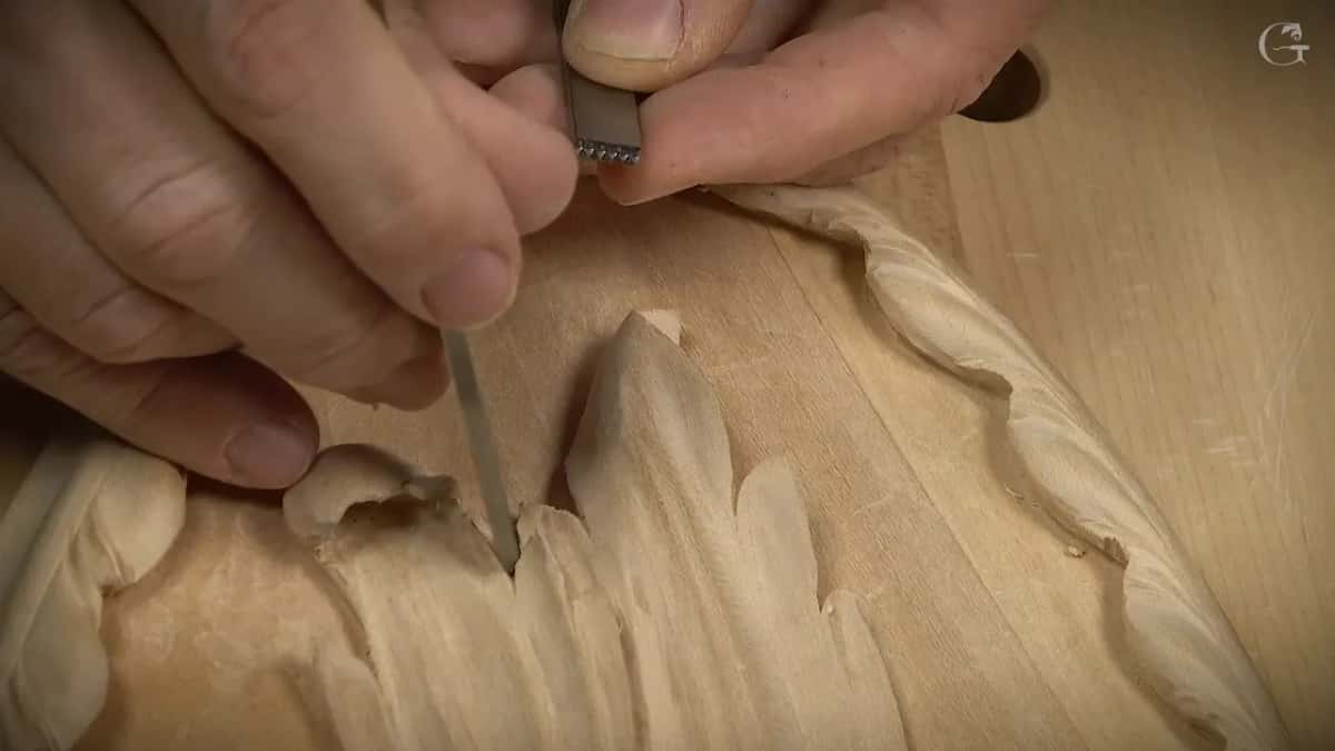 Fingertips turning up the end of a punch with one row of small teeth