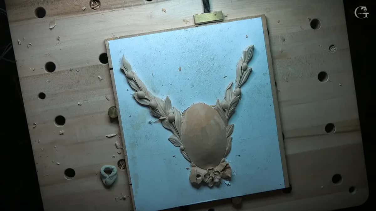 Whole rosette on a blue board, two sprays rising beside the plain oval, a lump of clay at left