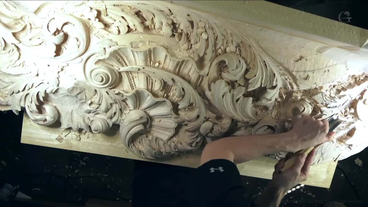 Long ornament panel with shells and scrolls, an arm reaching across to carve its far end