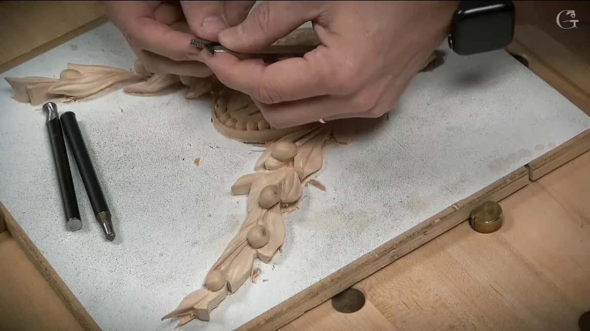 Two punches lie by a carved garland.