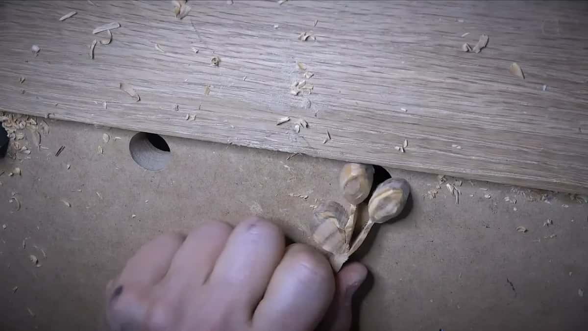Fingers pinch the olive's leg.