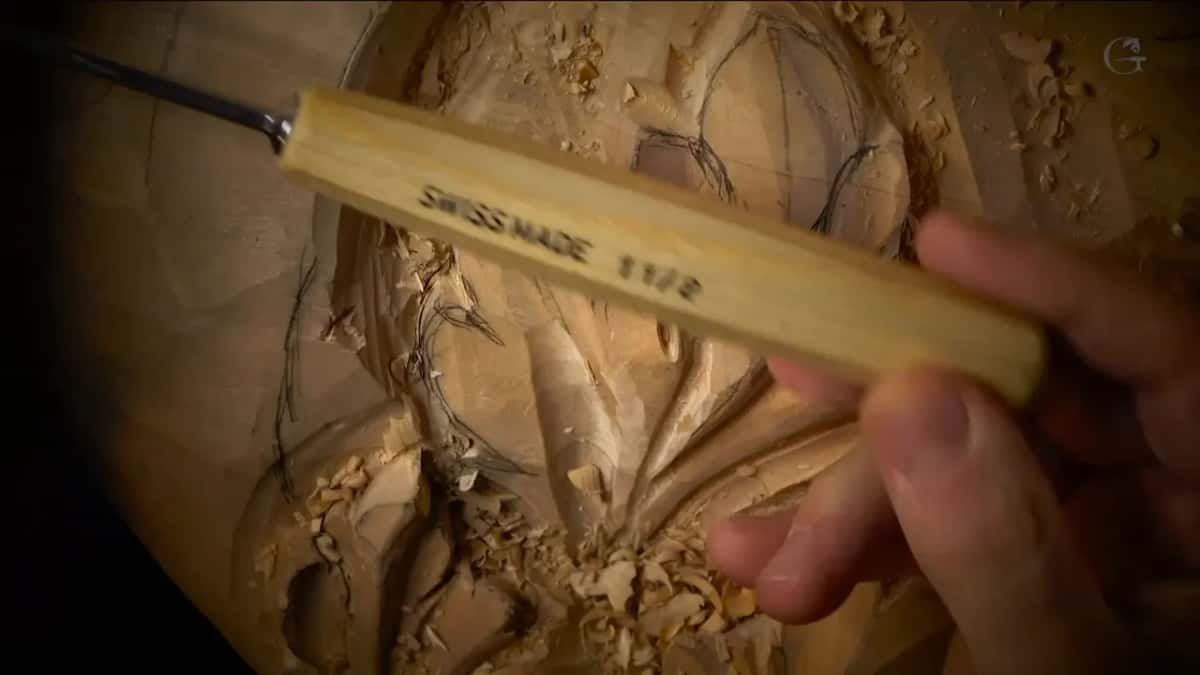 Pale handle across carved leaves