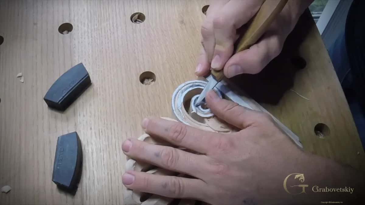 Close up from above, the knife sits down inside the channel and the spread hand keeps the whole piece still