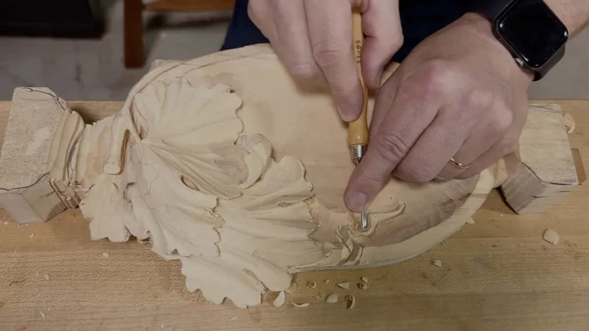 Both hands on one short tool, an index finger pressing near its tip