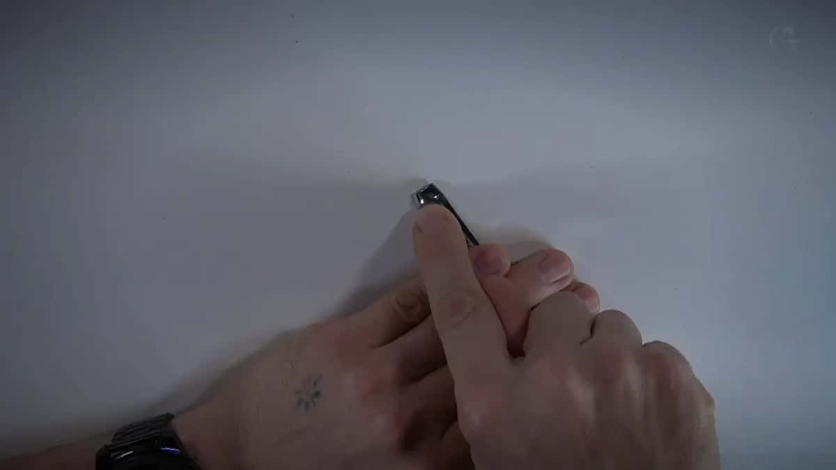Fingertips pinch a small gouge tip on white