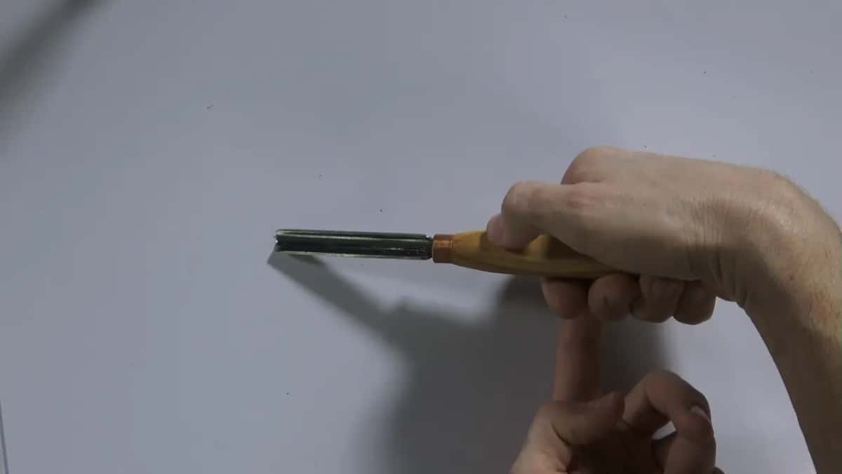 A fist closes around an orange handle, and under it one finger of the other hand points up