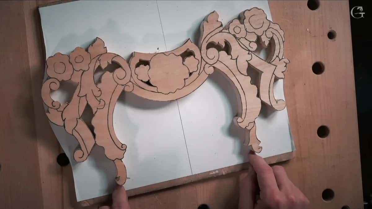 Sawn blank lying flat on white paper over plywood, two fingers at its lower edge