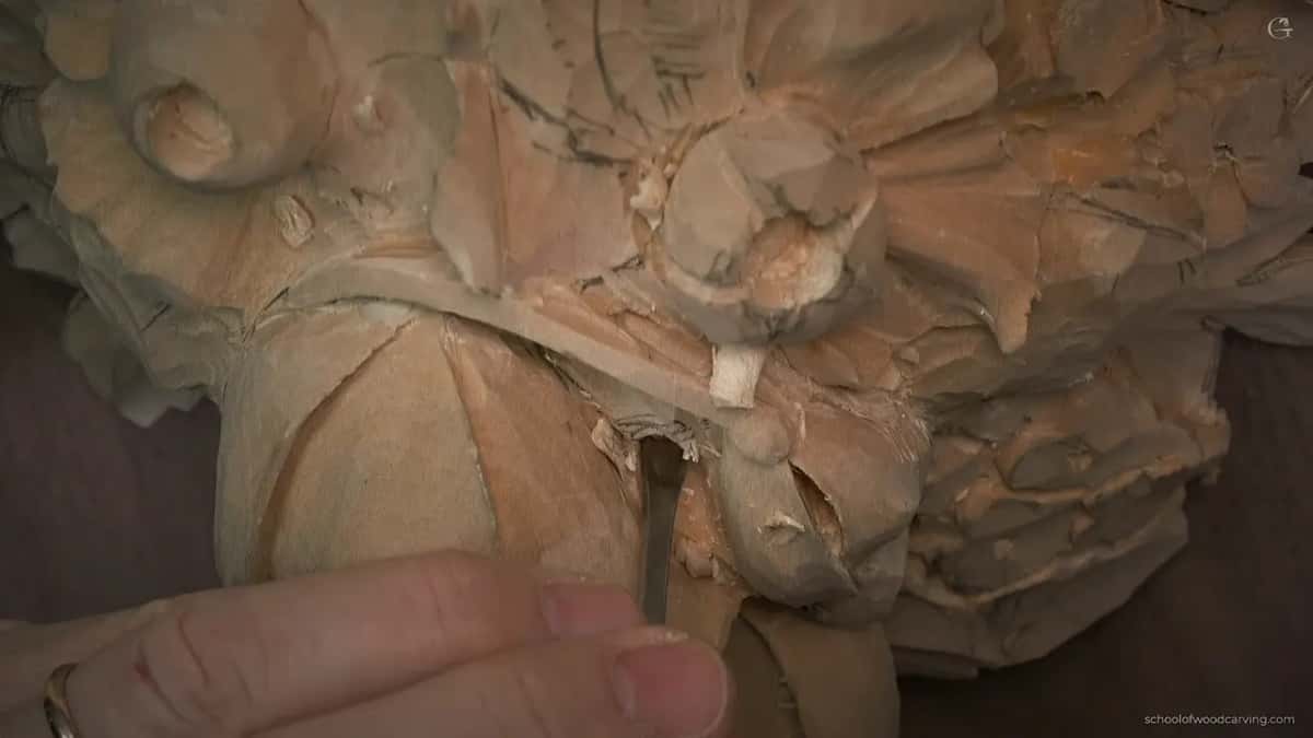 A gouge reaches down past the petals, deep into the block.