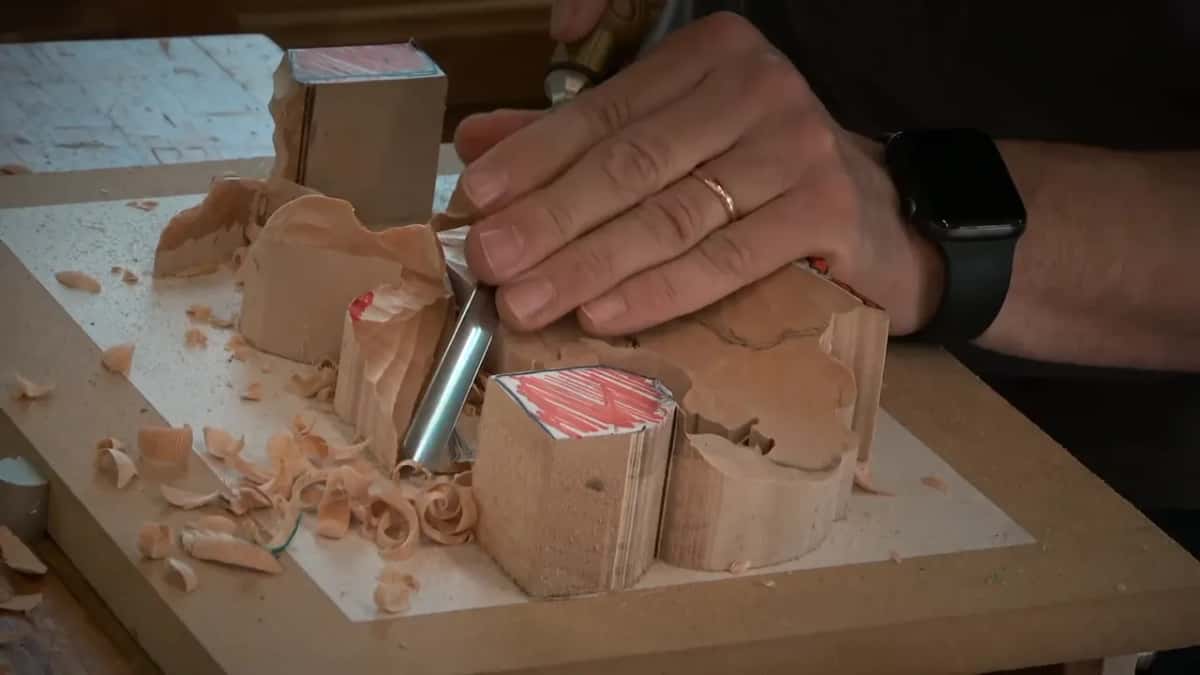 Deep in a hollow beside one corner block, the gouge sits with a curl of shaving at its edge