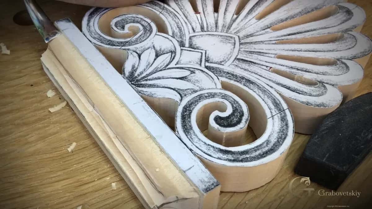 Stepped ogee carved along the plinth edge, with the swirls still papered