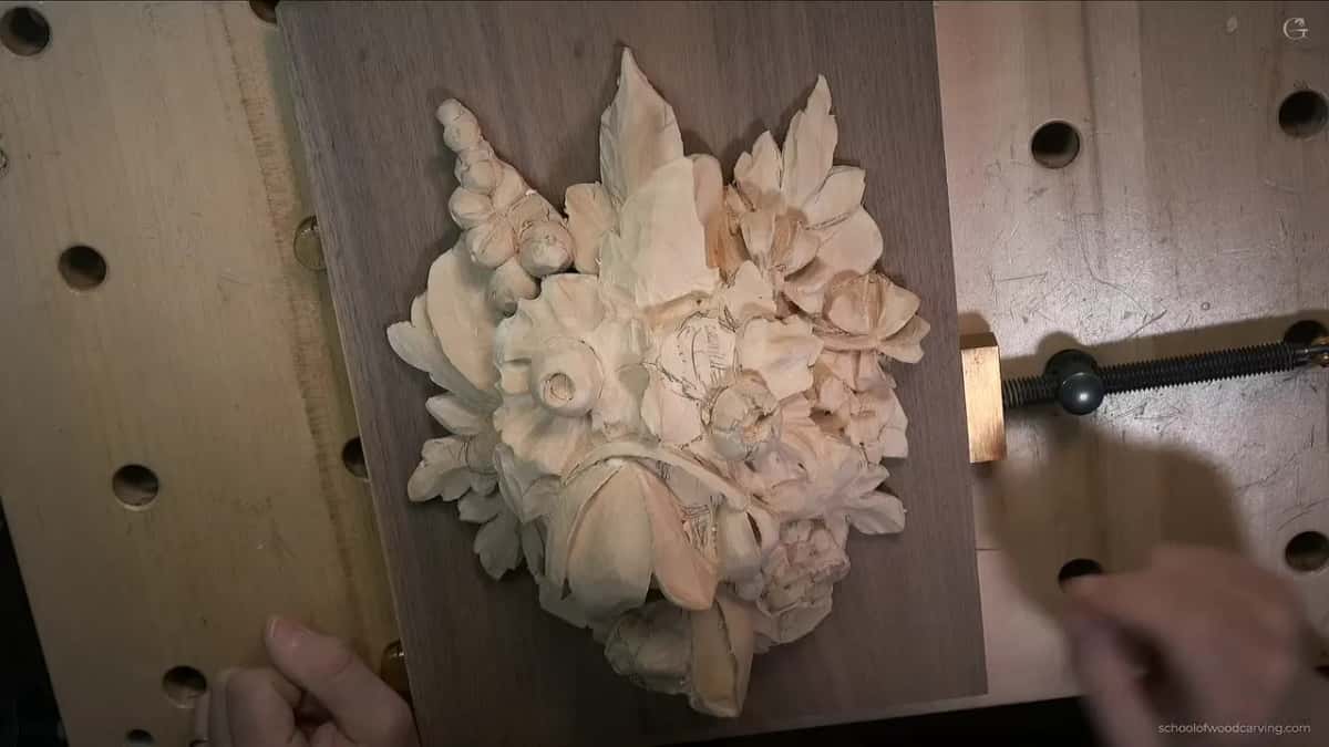 Grinling Gibbons style flowers in pale wood, mounted on a dark board.
