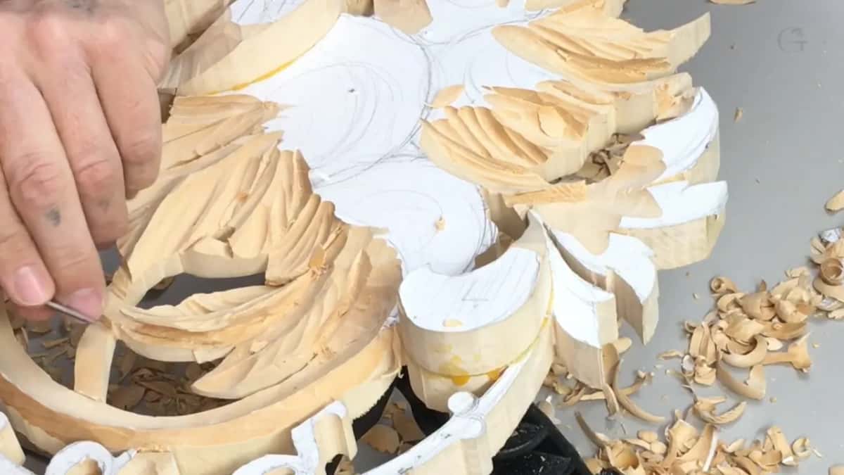 Leaves being carved while white paper still sits on top of the high spots around them