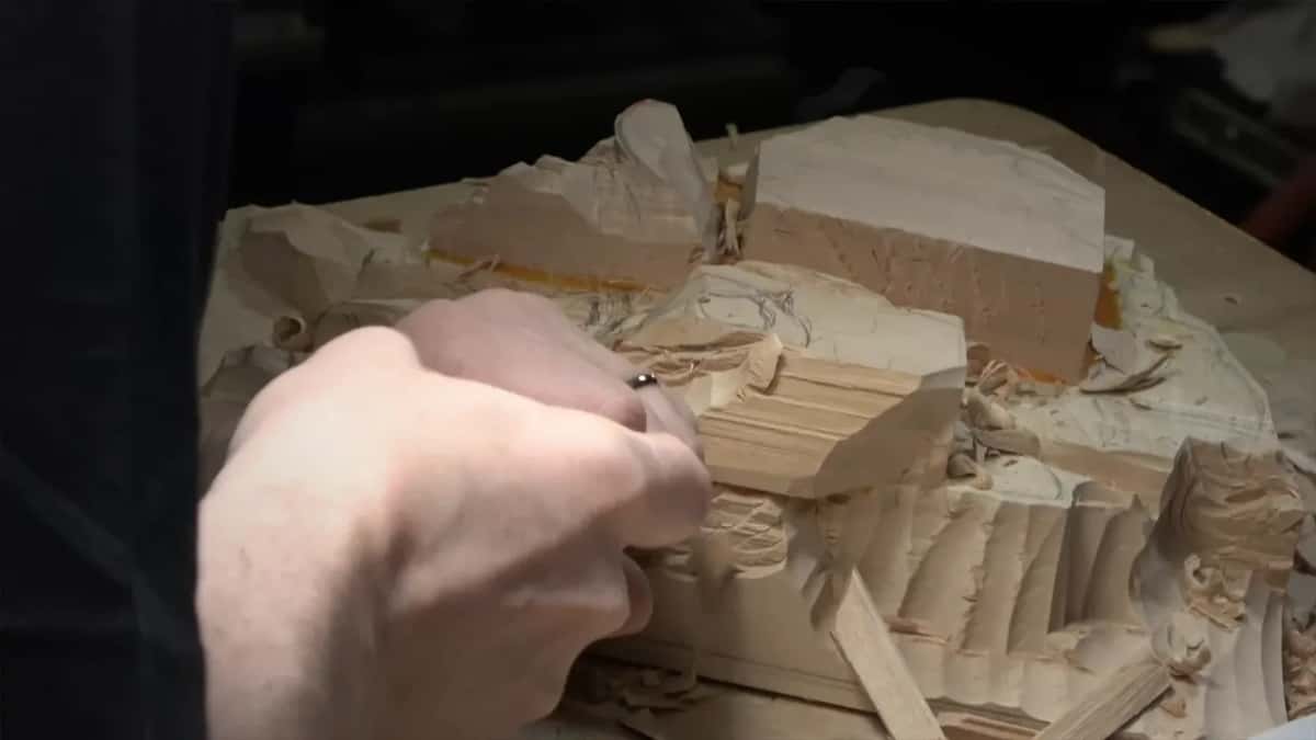 Hand pushing a gouge low along the side