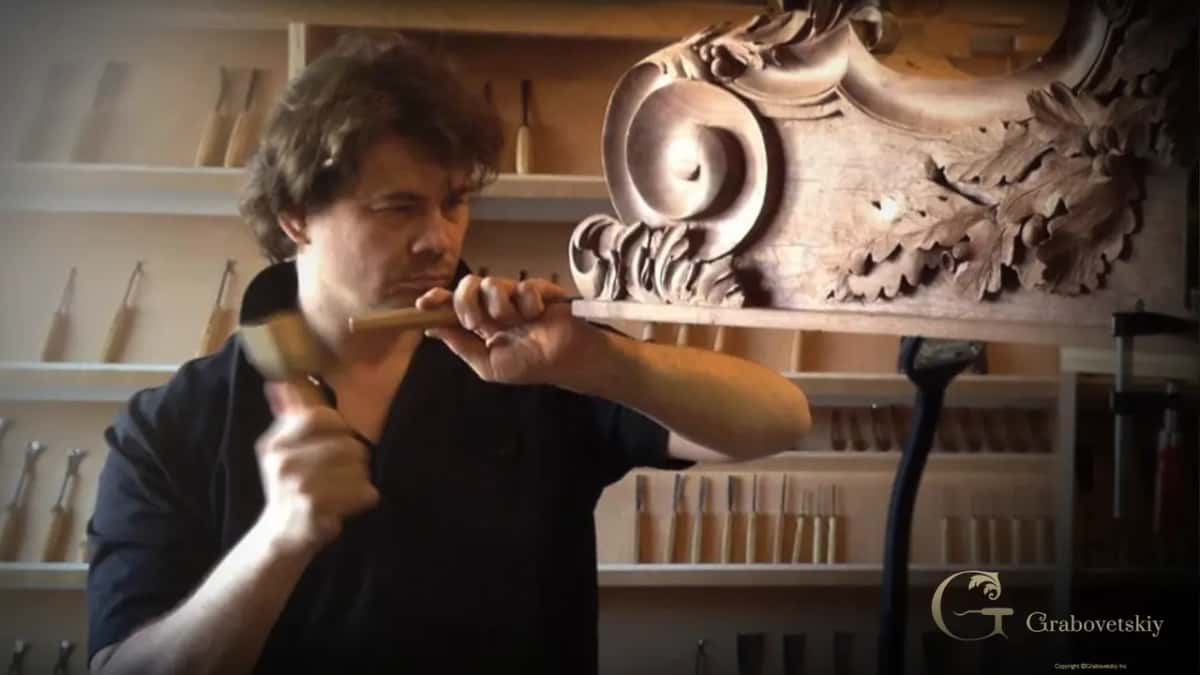 Mallet and gouge on a large scroll with oak leaves