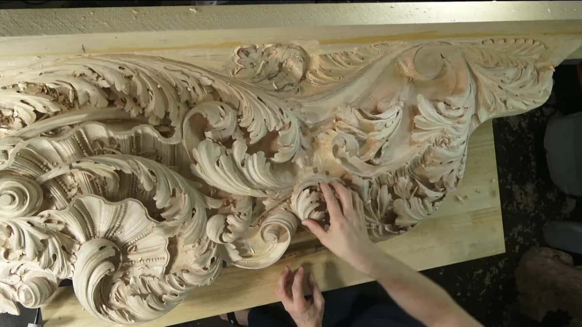 Big carved acanthus with both hands resting on it