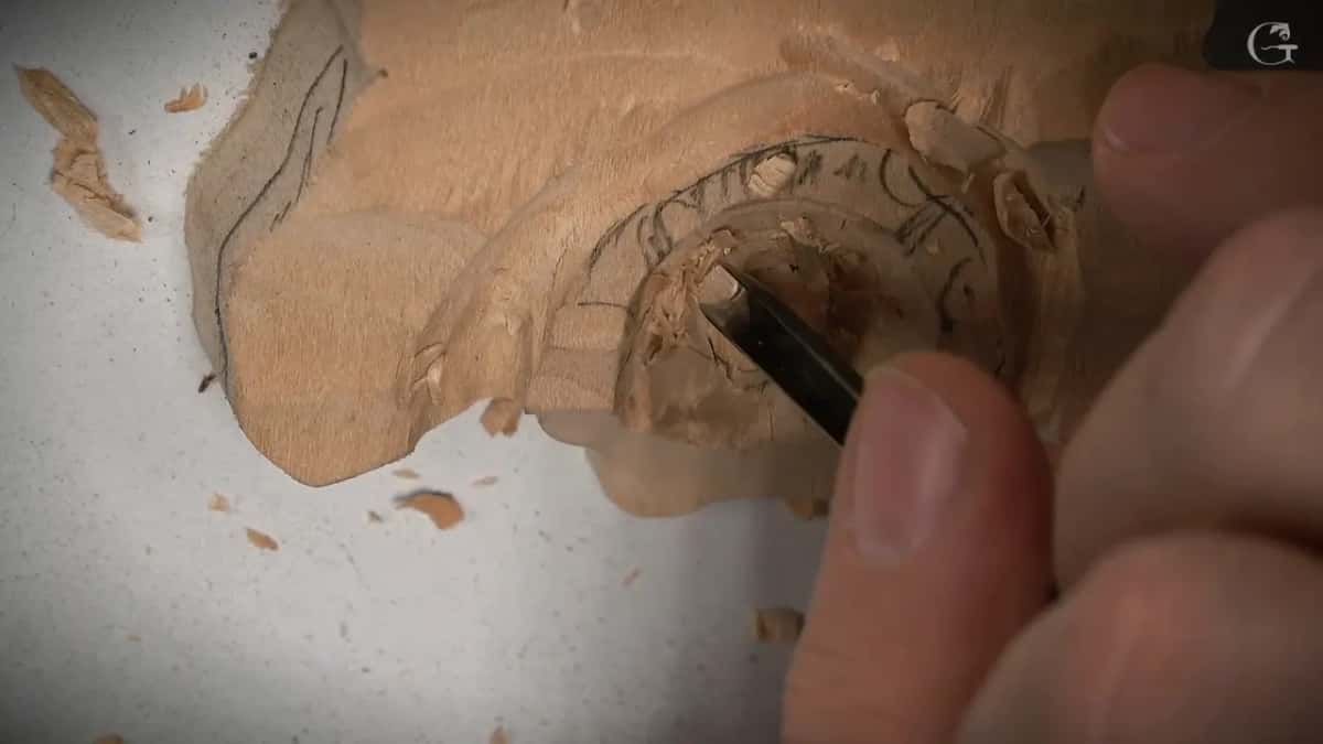 Fingertips steady a slim tool inside the raised ring