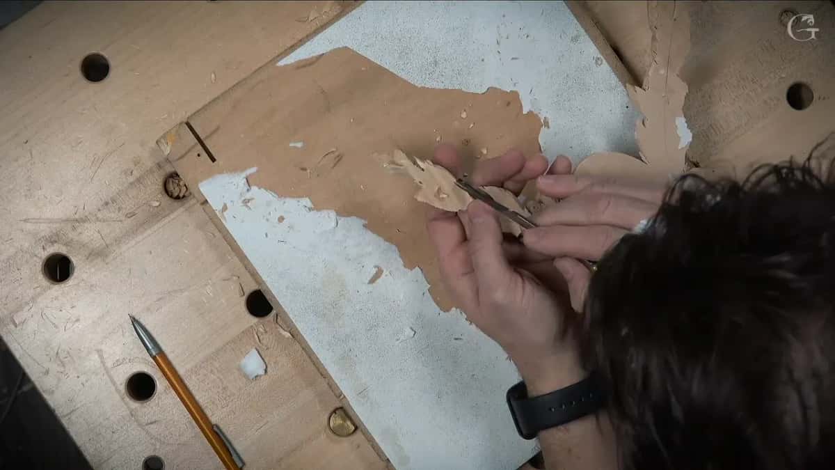 Working the back of the loose rosette by hand, torn paper left on the board