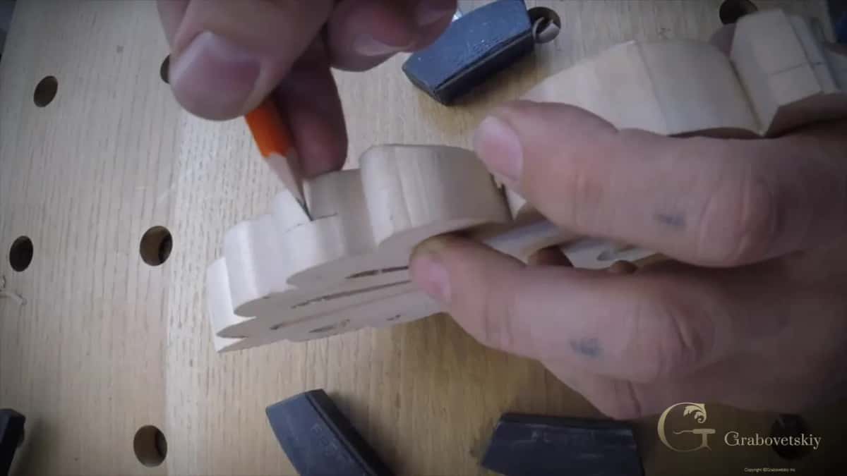 Pencil point and fingertips on the sawn edge