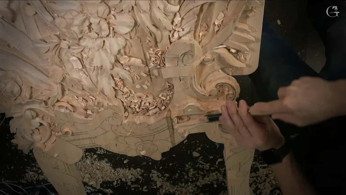 A narrow tool at the edge, both hands on it