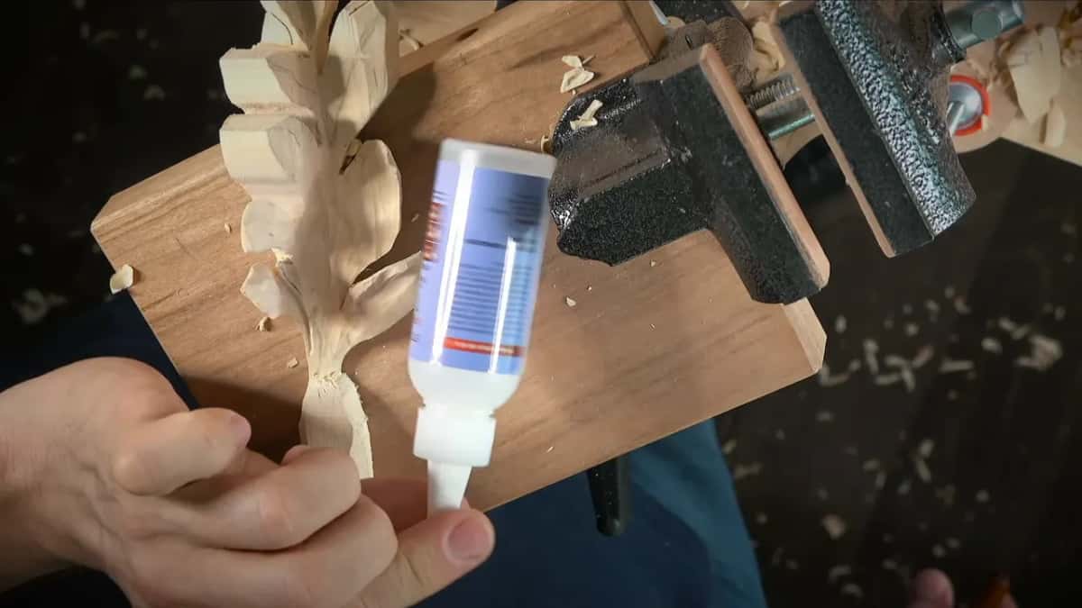Glue bottle held up beside the clamped leaf