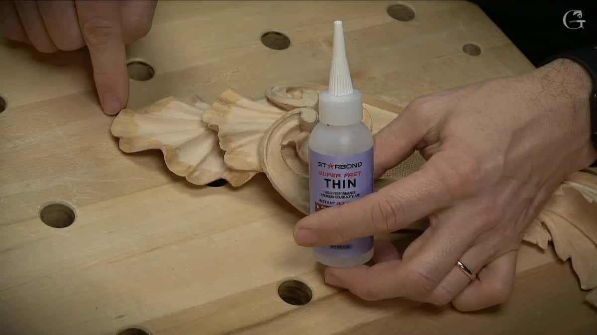 Starbond Super Fast Thin bottle held beside a carved scroll
