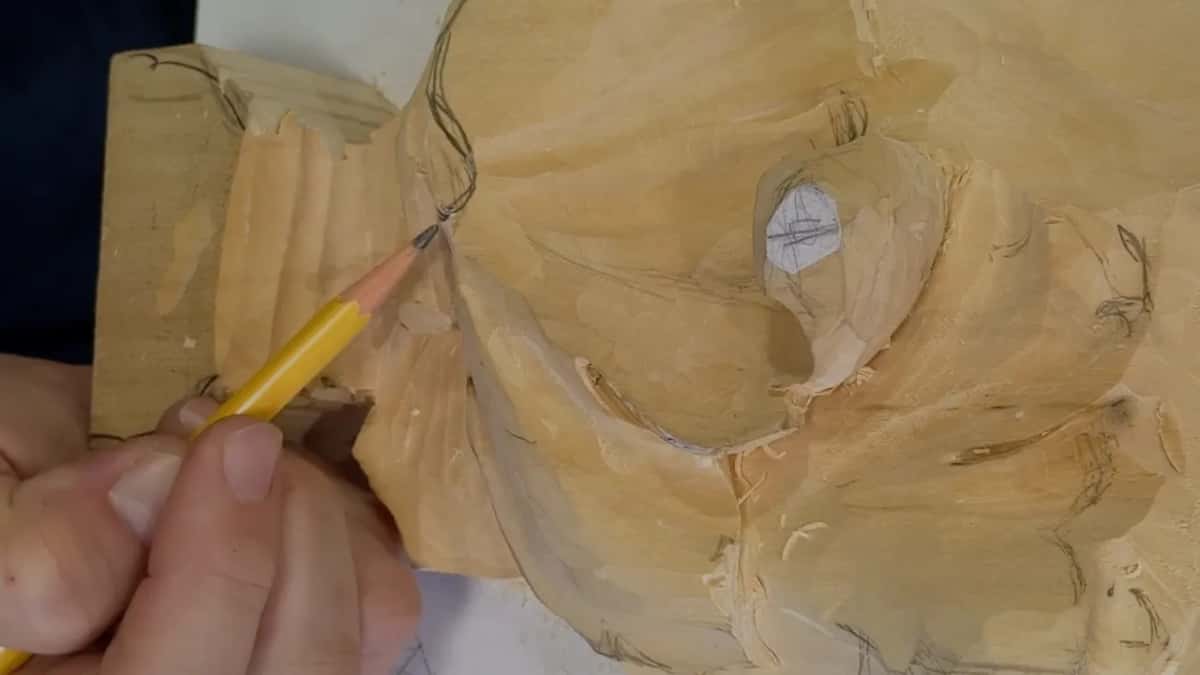 Pencil point resting where the grooved block at the left meets the leaf