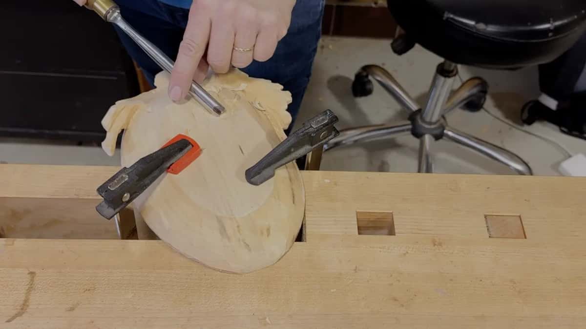 A long gouge lies across the grapes under two pressing fingers