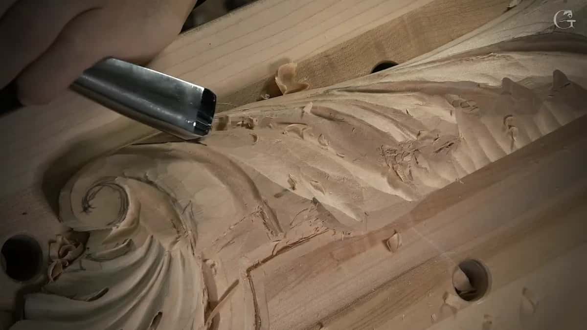 One deep sweep lifts a thin curl of wood near the scroll