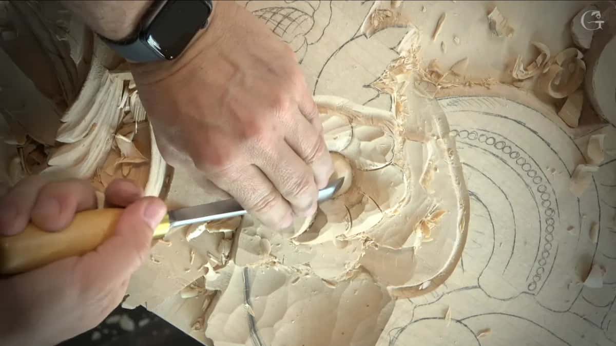 Gripping the wood handle in one fist, the other hand steering the blade into a petal