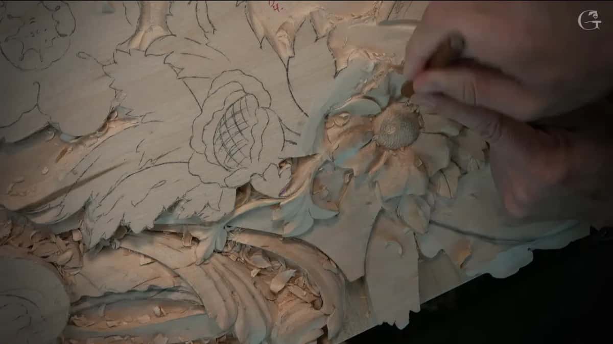 A small tool carving inside one petal, held in the right hand from above