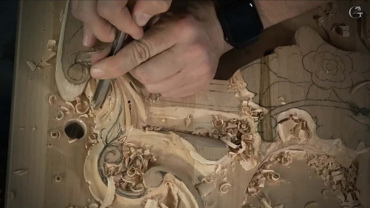 Close grip on the blade near its edge, wrist watch showing, a rose drawn in pencil to the right